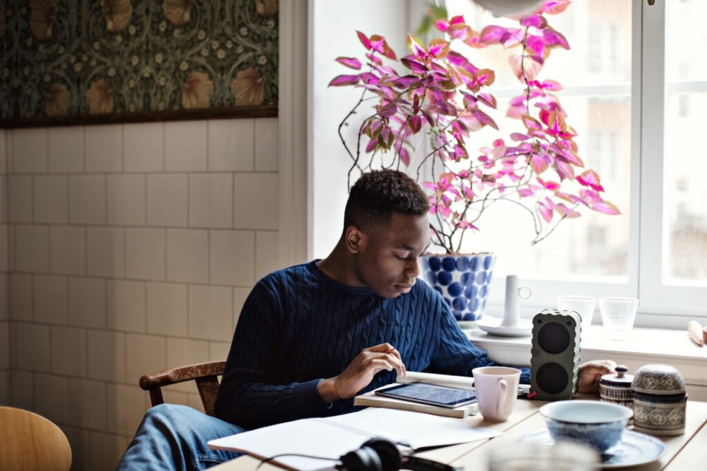 A man using tablet at home, reviewing mobile device safety measures provided by New Omni Bank