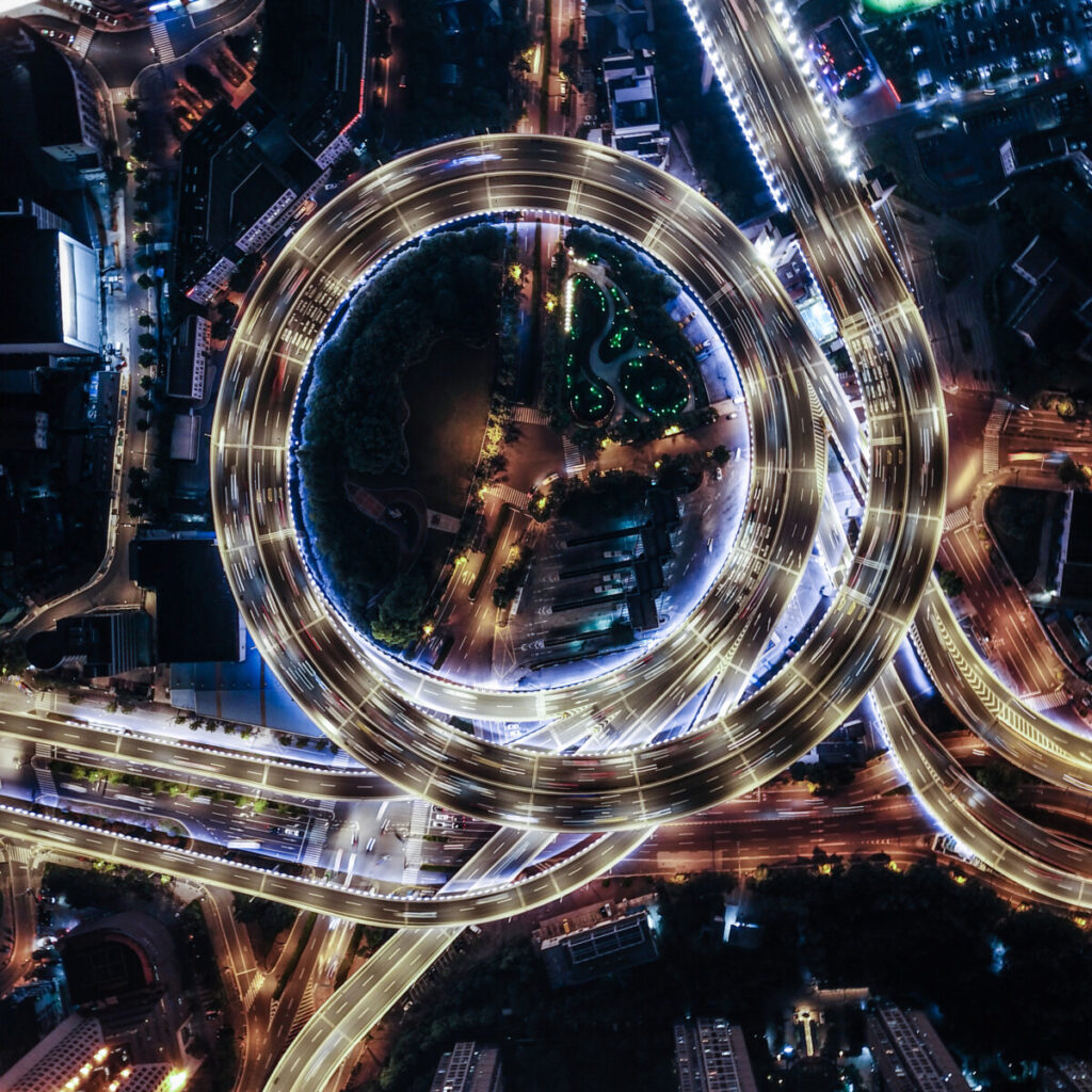 An aerial view of overpass and city traffic of an international city at night.