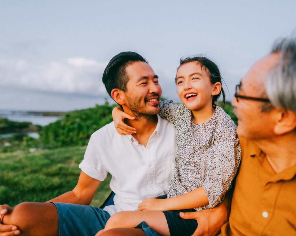 A three-generation family having a good time at dusk.