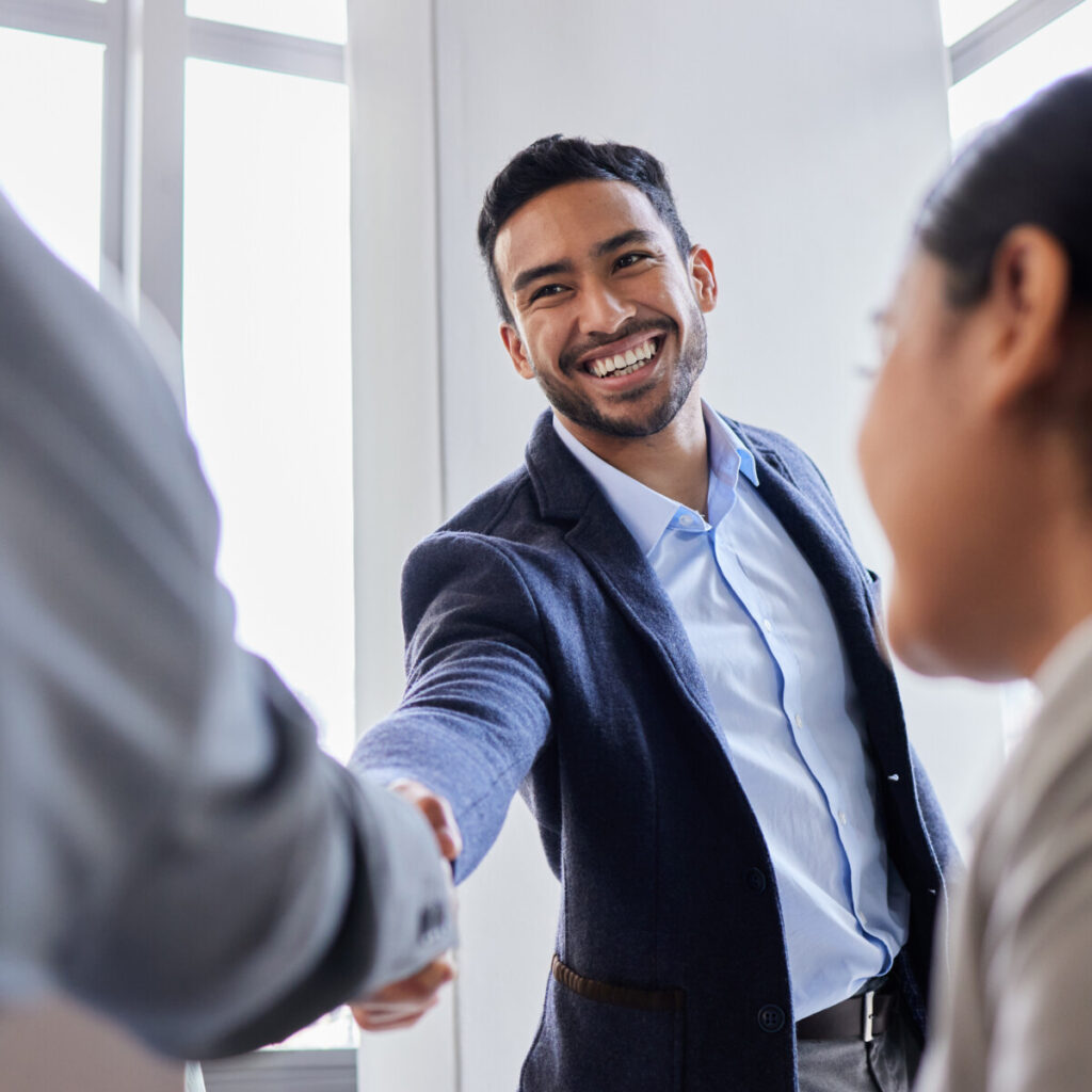 A New Omni Bank client shaking hands with another person in a networking event.