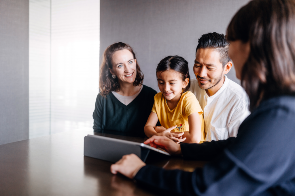 A family consulting with a New Omni Bank Relationship Manager in a meeting room.