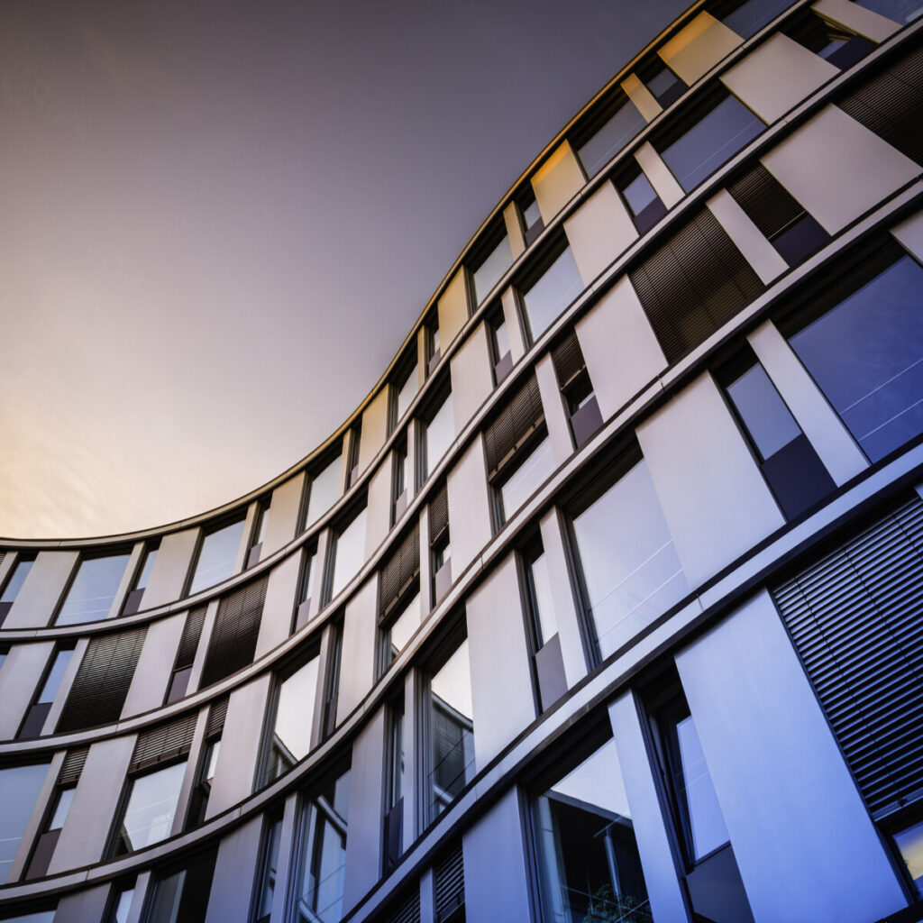 A modern, curved commercial building representing the potential unlocked by New Omni Bank's real estate loans.