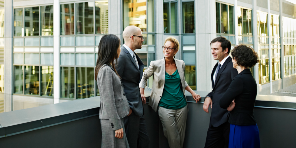 New Omni Bank: A group of diverse businesspeople talking on the balcony of an office building.