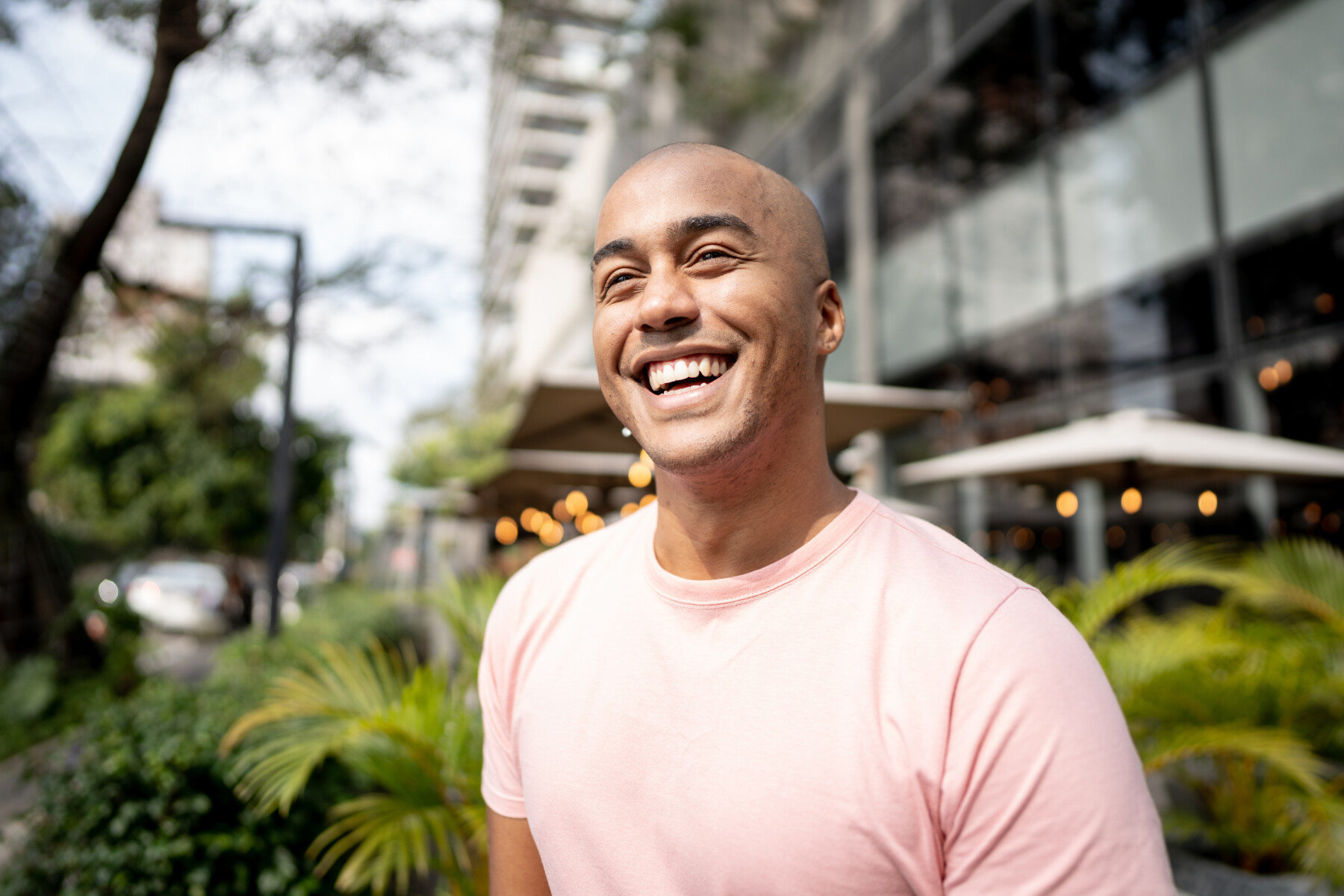 A happy young man looking away contemplating outdoors.