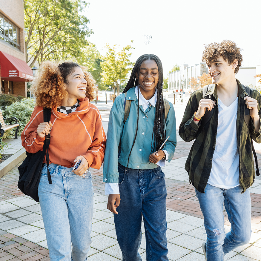 A diverse group of high school students laughing and talking together outdoors.