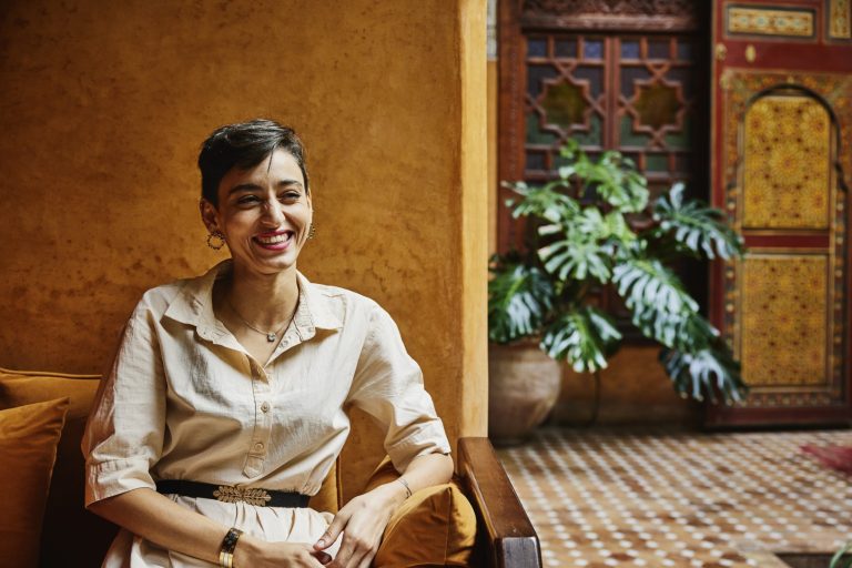 Smiling woman relaxing while on vacation, representing financial confidence and peace of mind.