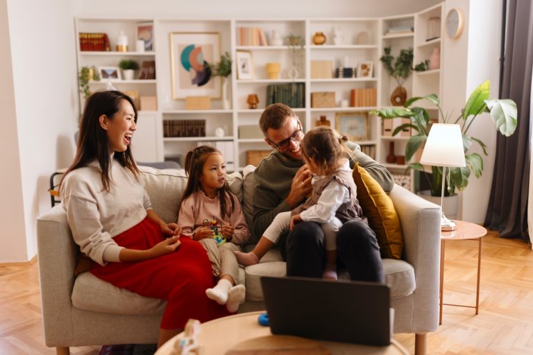 Parents spending time with their two daughters at home, symbolizing care and planning for their future.