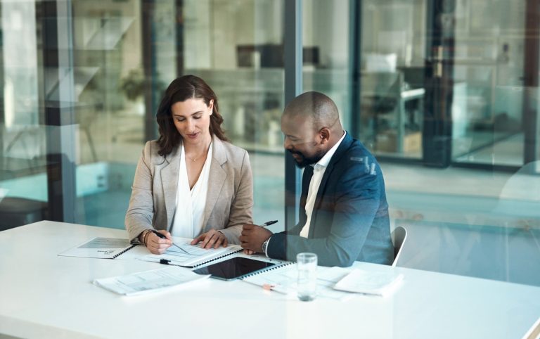 A business owner and a banker reviewing financing plans for a commercial & industrial loan.