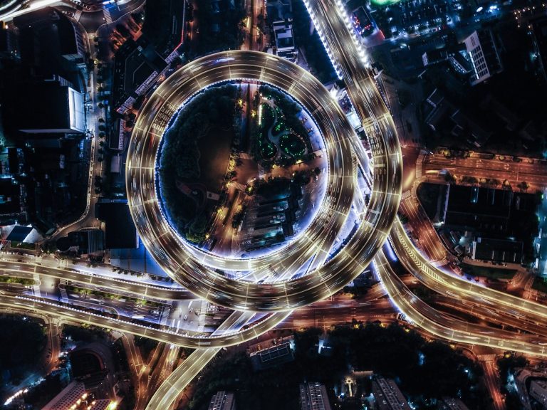 An aerial view of overpass and city traffic of an international city at night.