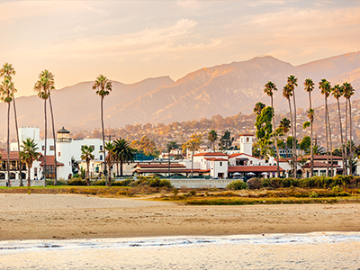 Santa Barbara beach with palm trees and city skyline at sunset, California, USA