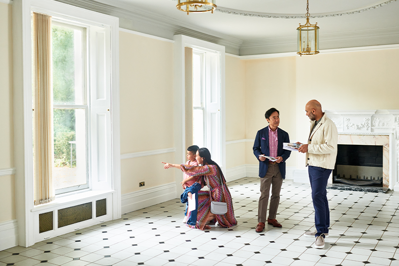 A real estate agent shows a new home to an Asian family.