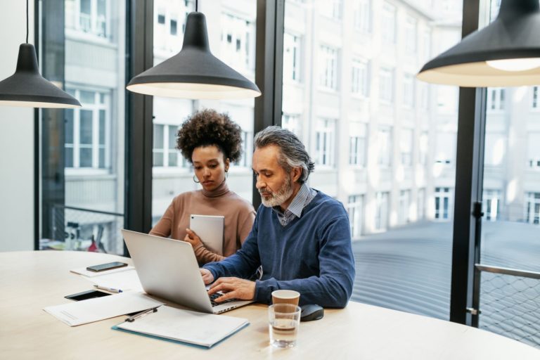 Business owners reviewing market trends and data insights on a laptop screen