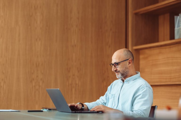 一位商業專業人士在現代辦公室中，使用筆記型電腦分析財務數據。