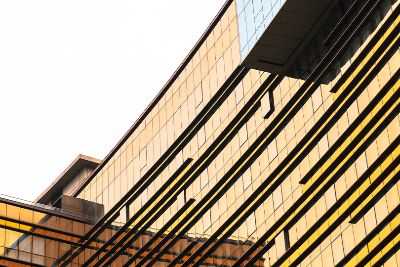 Modern commercial building exterior reflecting golden light, representing commercial real estate in Southern California