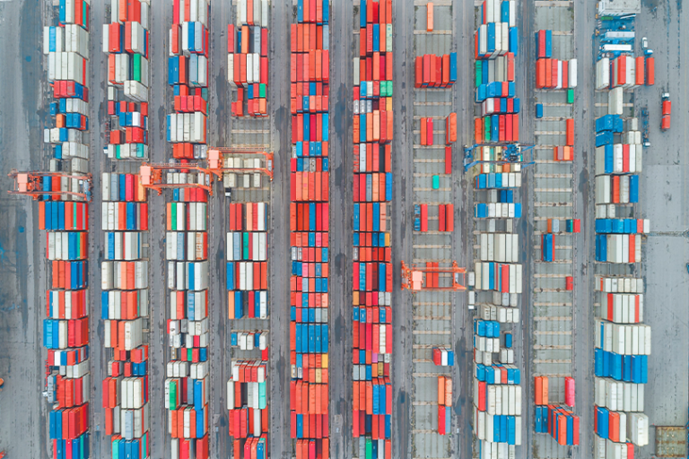 Aerial photograph of a container port showing dense rows of stacked shipping containers