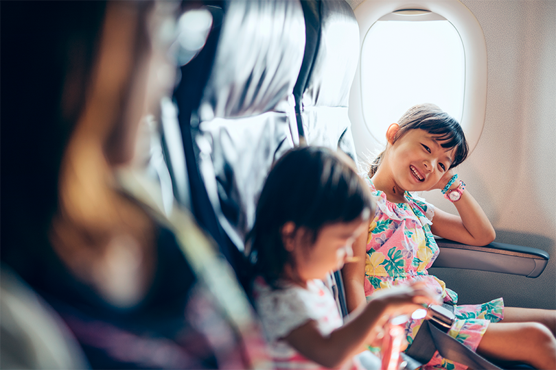 A little girl smiling on the airplane.