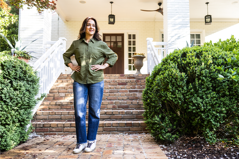 A woman standing in front of the entrance of her new home